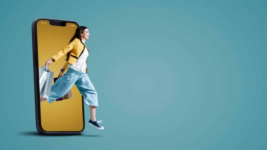 Happy young woman in a smartphone screen, she is running and holding shopping bags, online shopping promotional sale, blank copy space